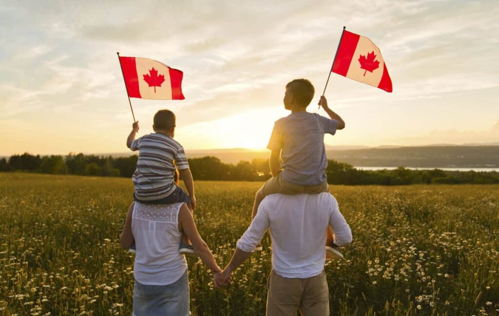 family standing with canadian flags in had "family sponsorship for immigration"